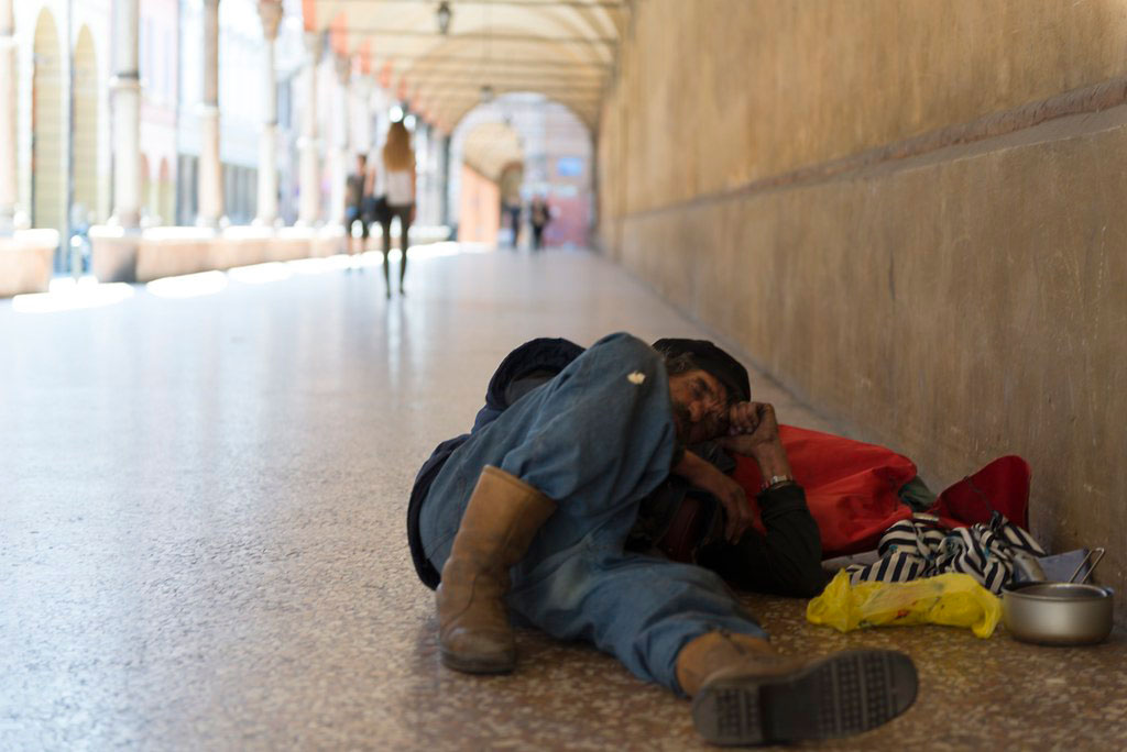 Clochard sotto i portici di Bologna